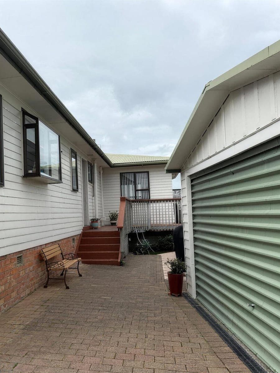 Old paint being stripped from a brick and weatherboard exterior on an EGP job