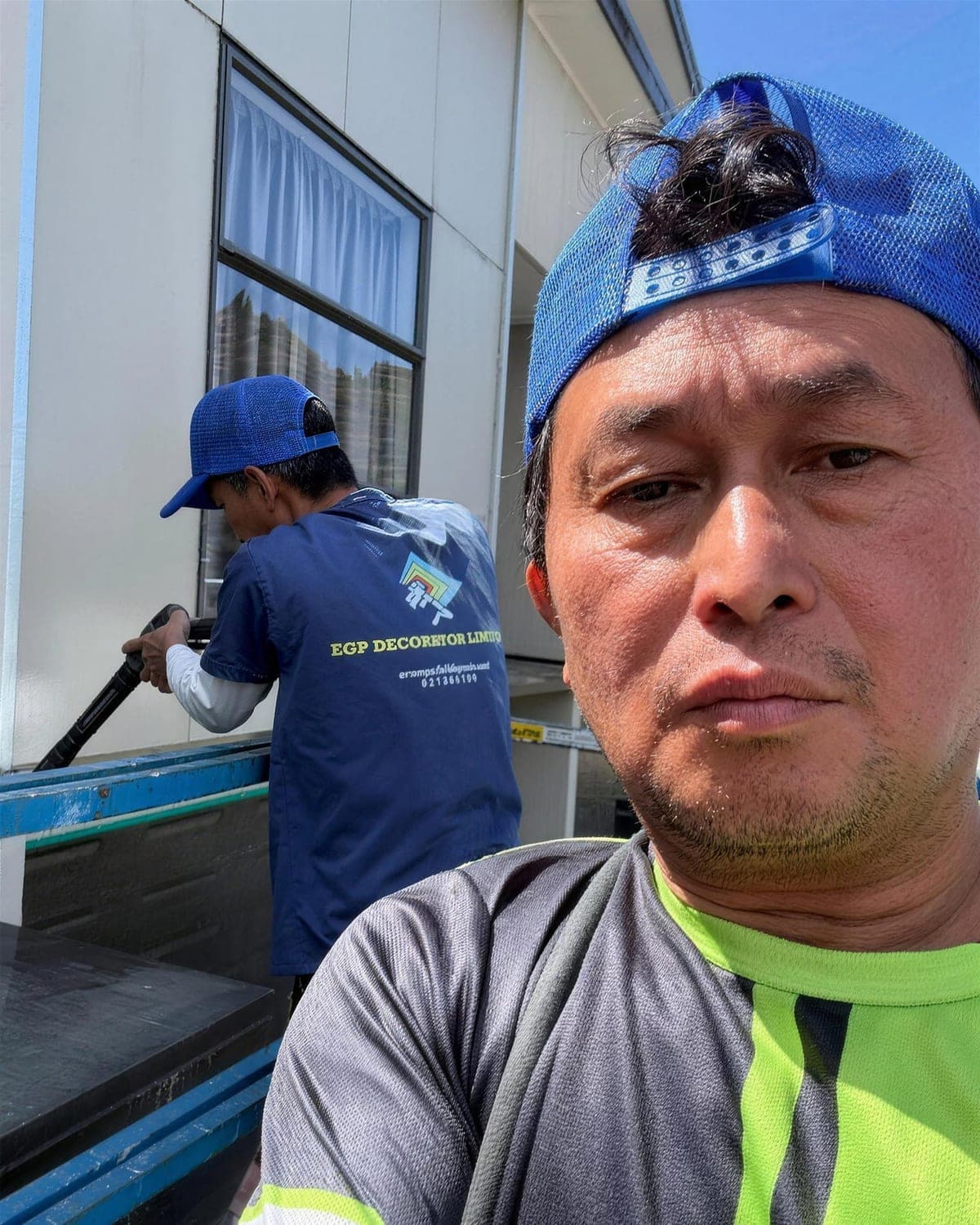 EGP crew in branded shirts working on an Auckland apartment exterior